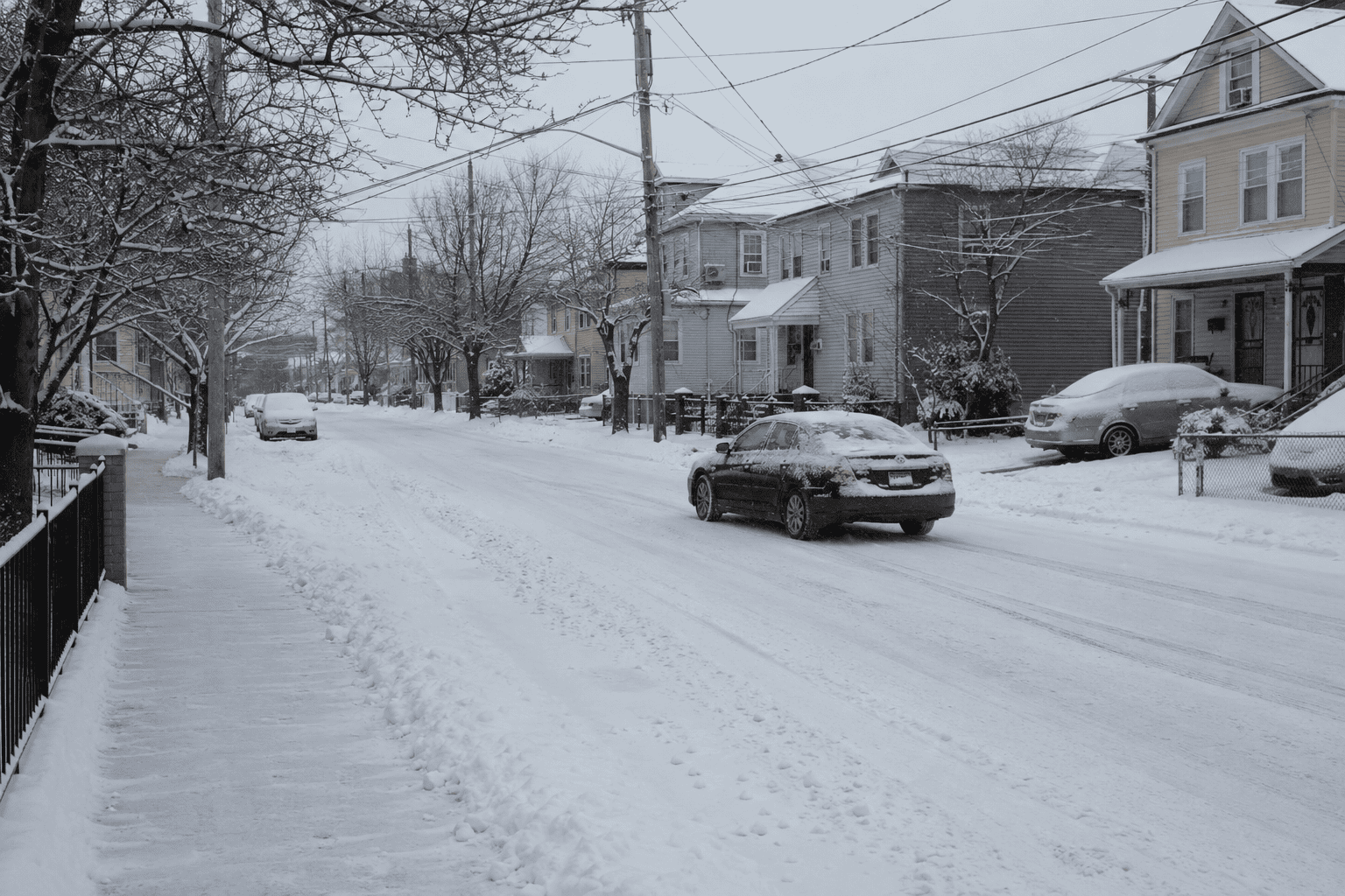 Cars being moved off a snow-covered residential street in Hackensack, New Jersey, during a snow emergency